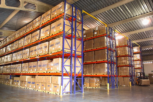 Selective pallet racking with blue uprights and orange beams holding cartons on pallets